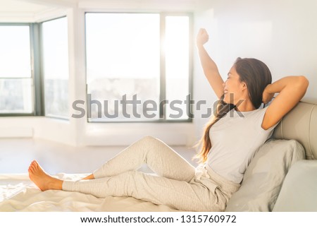 [[stock_photo]]: Waking Up Early Morning At Sunrise Happy Woman Yawning Stretching In Bed Sleeping At Home Woman Wak