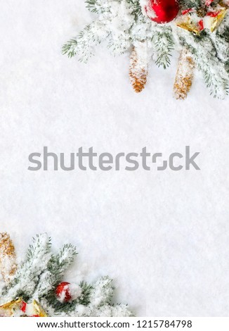 Foto d'archivio: Pine Branch With Cones And Red Christmas Bell On A Snowy Backgro