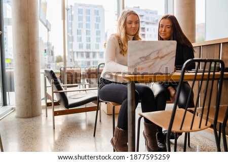 Stock photo: A Group Of Friends Sitting A Table And Talking Smiling While Ta