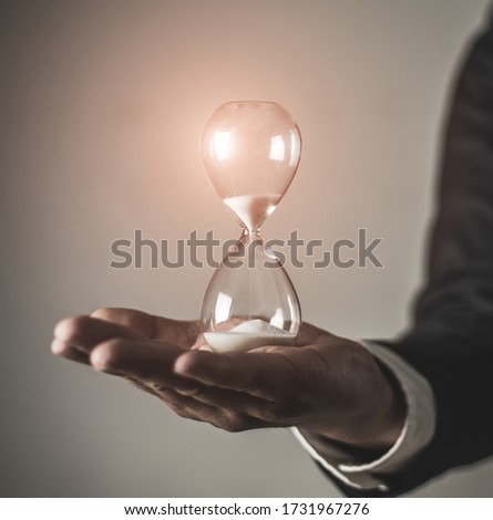 Imagine de stoc: Businessman Holding A Hourglass Concept Of Deadline In Business
