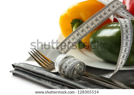 Foto d'archivio: Measuring Tape Wrapped Around Cutlery With Paprica Over White