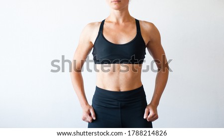 Stock photo: An Adult Woman In A Beautiful Muscular Body Against A Gray Wooden Wall