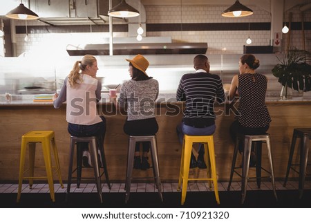 Foto d'archivio: Rear View Of A Group Of Multi Ethnic Friends Interacting With Each Others In Camper Van At Beach On