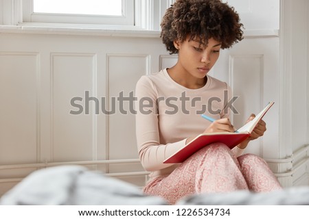 Zdjęcia stock: Woman Sitting At The Window Writing In Notebook Plan To Do List After Quarantine End Coronovirus