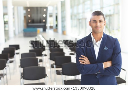 Foto d'archivio: Front View Of Handsome Mixed Race Businessman Standing On Stage In Auditorium Businessman Thinking