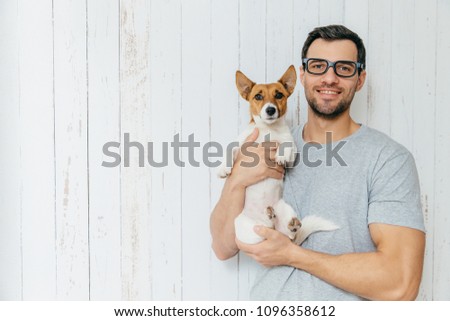 Stock foto: Positive Unshaven Male Wears Spectacles Holds Beautiful Bouquet Of Flowers Going To Present Them T