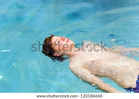 Stock photo: Boy With Red Hair Is Swimming In The Pool And Enyoing The Fresh