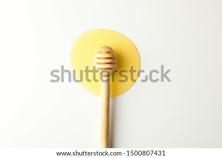 Foto stock: A Puddle Of A Natural Floral Sweet Dessert And Dripping Honey From Wooden Honey Dipper On A Gray Sto