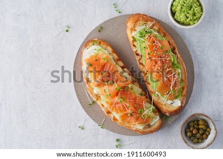Foto stock: Fresh Healthy Salmon Sandwich With Lettuce And Cucumber On Vintage Chopping Board On White Stone Bac