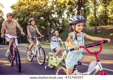 Stok fotoğraf: Happy Family Is Riding Bikes Outdoors And Smiling Mom On A Bike And Son On A Balancebike