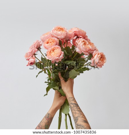 Сток-фото: A Girl With A Tattoo Holds A Bouquet Of Flowers Roses On A Pastel Background In A Trendy Color Of Th