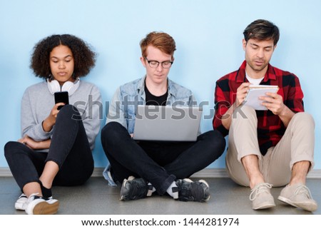 Stock photo: Thrre Young Groupmates With Gadgets And Notebook Working Individually