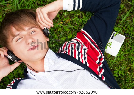 Stok fotoğraf: Student Outside Laying On Grass And Listening Music School Phot