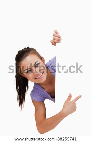 Zdjęcia stock: Young Female Pointing Around The Corner Against A White Background