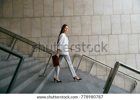 Stockfoto: Lifestyle Portrait Of Young Stylish Woman Goes In The City With A Red Trendy Bag On The Girl Should