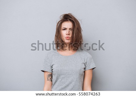 Сток-фото: Charming Young Girl In A Gray T Shirt On A Gray Background Girl In Red Square Eyed Glasses The Gir