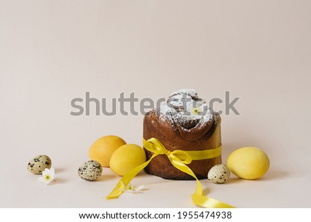 Stockfoto: Slice Of Easter Bread With Colorful Eggs And Yellow Tulips On Blue Wooden Background