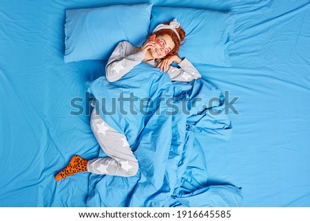 [[stock_photo]]: Indoor Shot Of Beautiful Redhead European Woman Has Rest After Cardio Training Keeps Legs Crossed