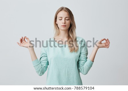 Foto stock: Young Blond Girl Meditating With Closed Eyes In Lotus Pose Yoga