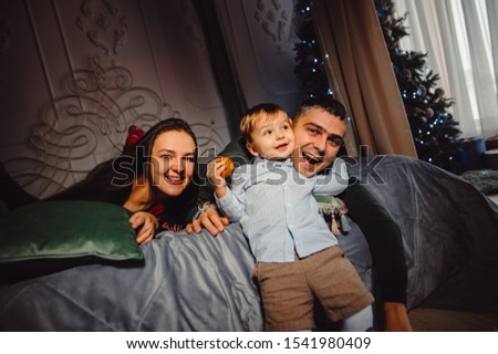 Zdjęcia stock: Happy Mother And Son Jumping On The Bed Against The Backdrop Of A Large Window Overlooking The Skysc