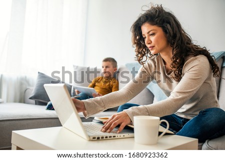 Stockfoto: Woman Drinking A Coffee And Using Her Laptop In The Living Room