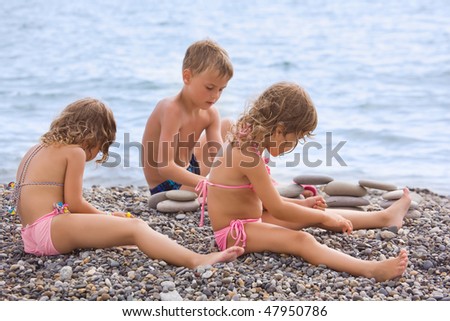 Stockfoto: Inderen · Drie · Samen · Zittend · Op · Steenachtig · Strand · Creëert · Piramide