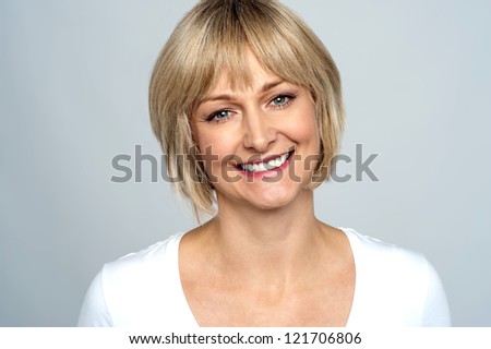 Stockfoto: Portrait Of A Smiling Middle Aged Caucasian Woman Against Dark Background