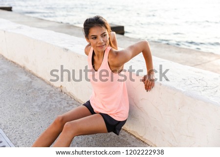 Stockfoto: Photo Of Energetic Sporty Woman 20s In Tracksuit Squatting Duri