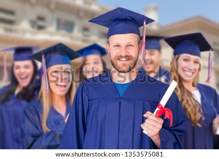 Stock fotó: Proud Male Graduate In Cap And Gown In Front Of Other Graduates