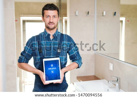 Stock fotó: Technician Of Home Service Company Holding Touchpad With Homepage On Display