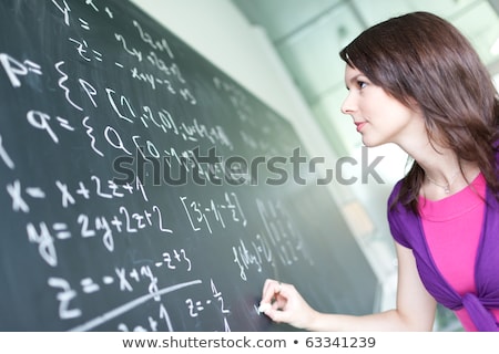 Foto stock: Pretty Young College Student Writing On The Chalkboard