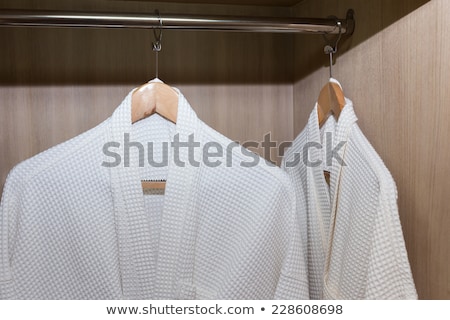 Stockfoto: White Robes With Wooden Hangers In Hotel Closet