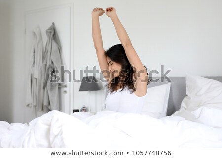 Foto stock: Ulher · jovem · acordando · na · cama