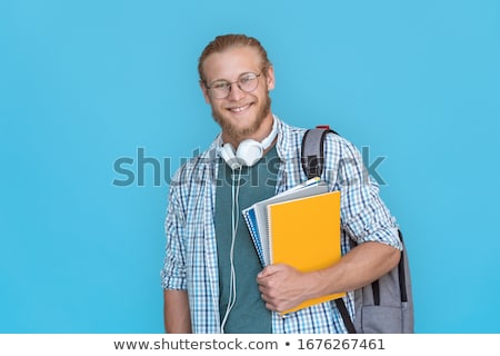[[stock_photo]]: Bearded Student Holding Copybooks And Looking At Camera Isolated On White