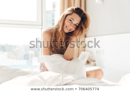 Stock fotó: Smiling Woman Sitting With Pillow In Bed