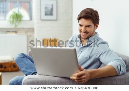 ストックフォト: Smiling Young Man Using Laptop Computer