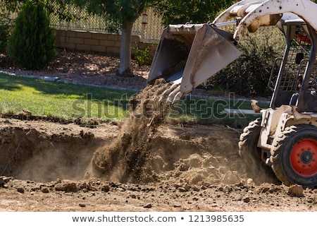 Foto stock: Small Bulldozer Removing Grass From Yard Preparing For Pool Inst