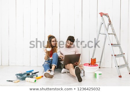 Stock photo: Photo Of Cheerful Couple Man And Woman Using Ladder While Paint
