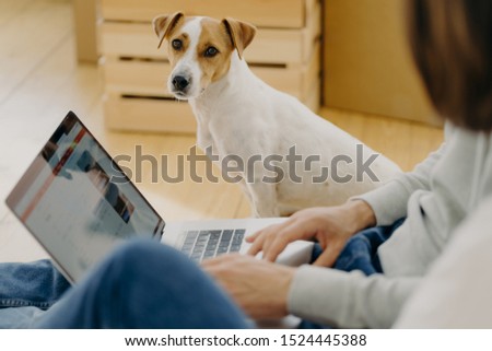 Foto stock: Unrecognizable Man Works On Laptop Comuter Keyboards And Surfs Internet Webpage Sits On Floor Near