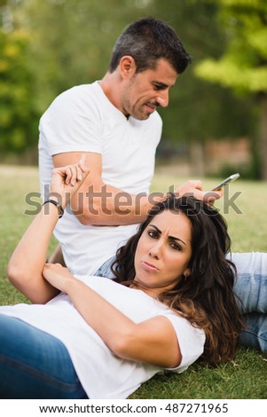 [[stock_photo]]: Bored And Angry Woman Pointing To Her Husband For Ignoring And Using Smartphone For Texting Instead