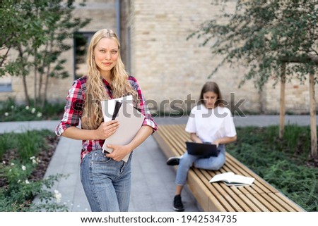 Stock photo: Happy Two Friends Women In Park Holding Laptop Computer Waving To Friends