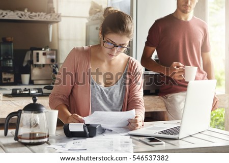 Foto stock: Young Woman With Her Husband Calculate Home Budget In The Kitchen