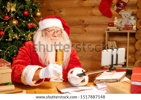 Stok fotoğraf: Santa With Flute Of Champagne Holding Smartphone On Stick While Making Selfie