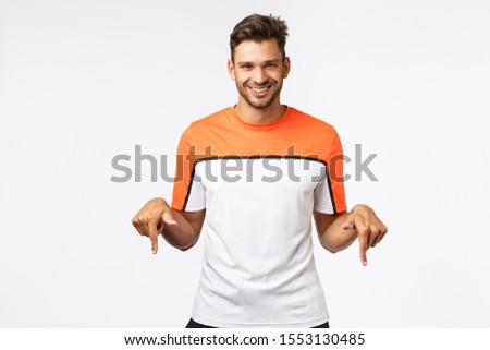 Сток-фото: Cheerful Handsome Smiling Sportsman In Activewear Pointing Camera And Grinning Holding Bottle Enco