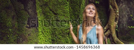 Сток-фото: Young Woman Traveler In A Balinese Garden Overgrown With Moss Travel To Bali Concept Banner Long F