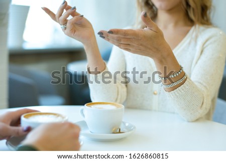 Foto d'archivio: Hands Of Young Casual Female With Bracelets Explaining Something To Her Friend