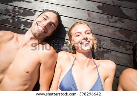 Foto stock: Portrait Of Beautiful Woman Lying On Wooden Deck By Pool Side