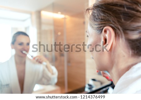 Stock fotó: Woman Brushing Her Teeth In Luxurious Hotel Looking At Herself