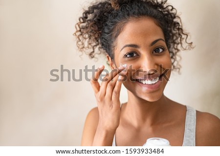 Stock photo: Smiling Woman Applying Face Cream