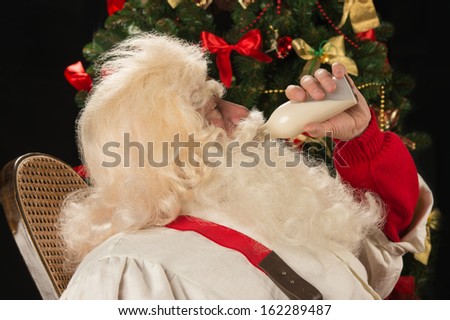 Stockfoto: Happy Santa Claus Drinking Milk From Glass Bottle Against Christ